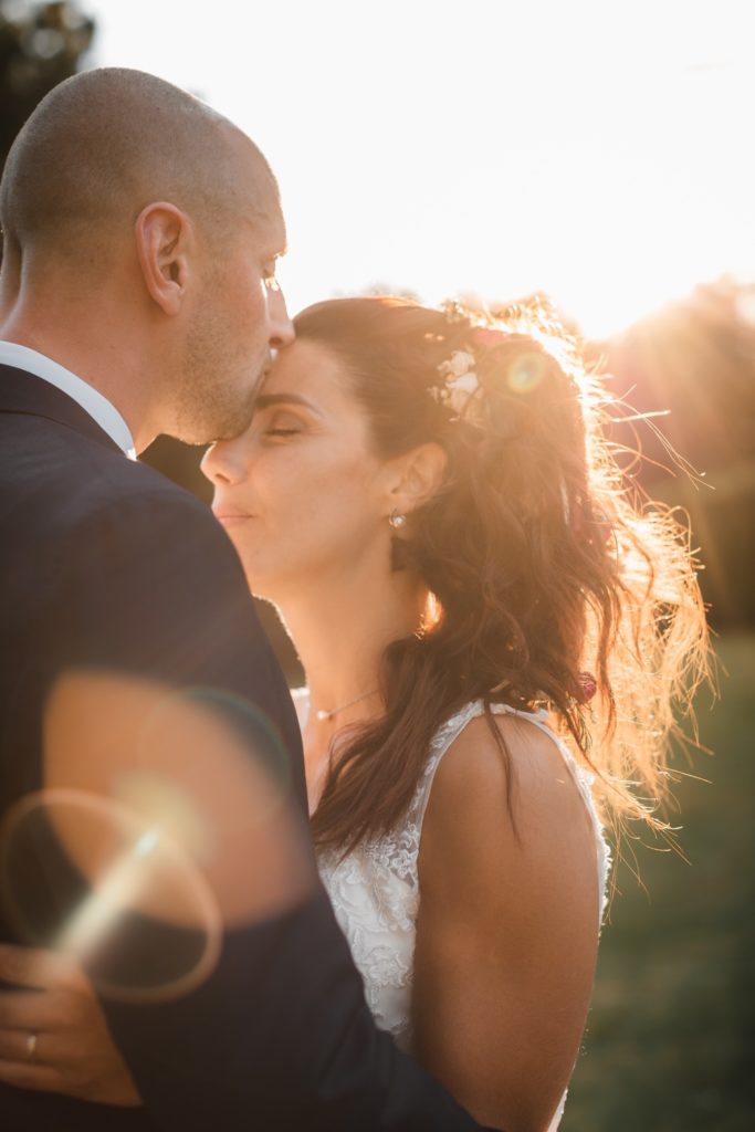 Capture du moment où le marié embrasse la mariée sur le front, par Olivier Chevalier